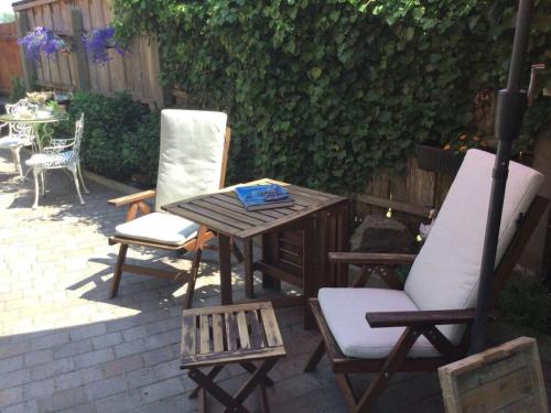 a wooden table and two chairs and a table and chairs at Haus Am Deich Modern retreat in Cadenberge