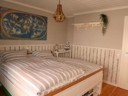 1 dormitorio con 1 cama con una pintura en la pared en Haus Am Deich Modern retreat, en Cadenberge