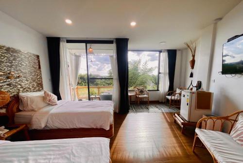 a hotel room with two beds and a window at Pupah Kanna Pua-ปู๋ ป๋าล์ คันนา ปัว in Pua