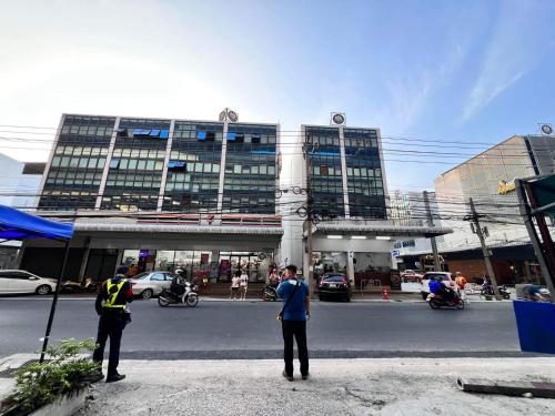 two people standing on the street in front of a building at Luna hotel สถานีดอนเมือง in Ban Don Muang (1)