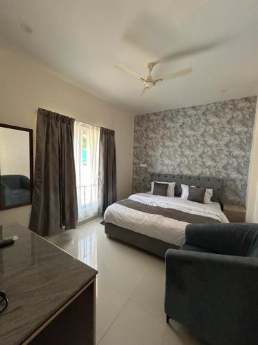 a bedroom with a bed and a couch at Sapphire Stayss in Yelagiri