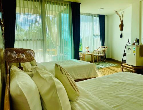 a hotel room with two beds and a window at Pupah Kanna Pua-ปู๋ ป๋าล์ คันนา ปัว in Pua