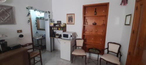 a kitchen with chairs and a counter with a microwave at I Cappuccini B&B in Sorso