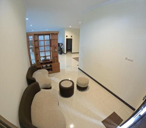 uma sala de estar com dois bancos e um espelho em Griya Sukoharjo Homestay Jogja em Ngemplak