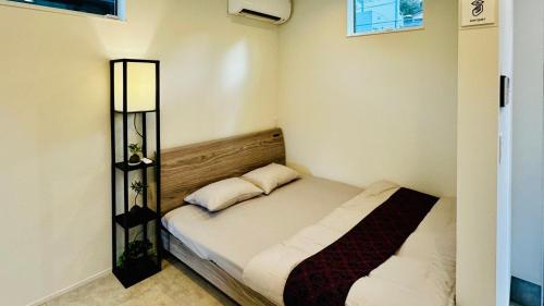 een kleine slaapkamer met een bed in een kamer bij 加美屋リゾート伊勢神宮 おかげテラス in Uji