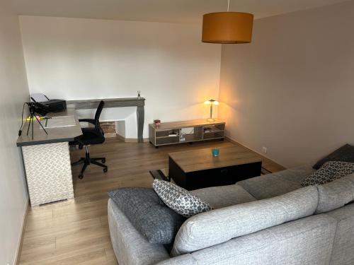 a living room with a couch and a desk at Appart in Rougemont