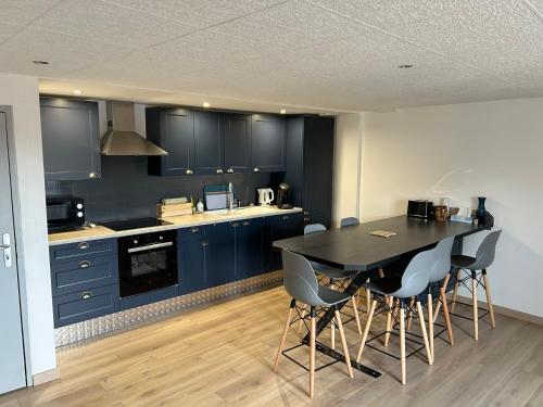 a kitchen with blue cabinets and a table and chairs at Appart in Rougemont