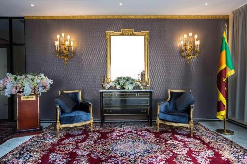um quarto com duas cadeiras e uma cómoda e uma bandeira em Lotus Grand View Hotel em Horana