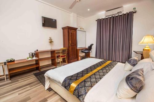 um quarto com uma cama, uma secretária e um computador em Lotus Grand View Hotel em Horana