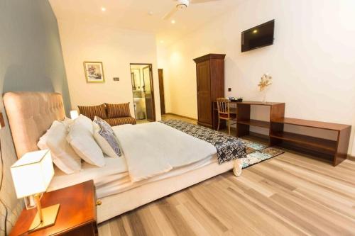 um quarto com uma cama, uma secretária e uma televisão em Lotus Grand View Hotel em Horana