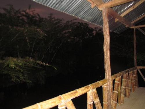 een houten leuning op een veranda 's nachts bij Yaku Wasi Lodge in Puerto Misahuallí