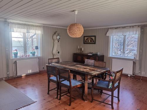 a dining room with a wooden table and chairs at Embracing nature's Swedish house in Ludvika