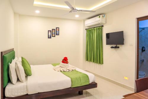a bedroom with a bed and a tv on the wall at SAARA INN in Puducherry