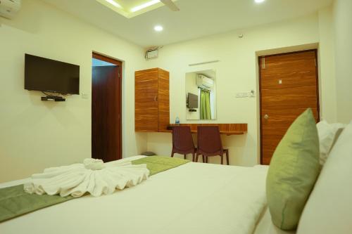 a bedroom with a bed with a television and a desk at SAARA INN in Pondicherry