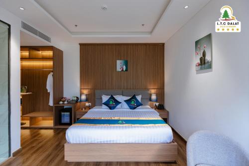 a bedroom with a large bed with blue pillows at Rung Thong Nui Voi Villa & Resort in Ðưc Trọng