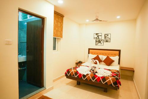 a bedroom with a bed with a demon on it at SAARA INN in Puducherry