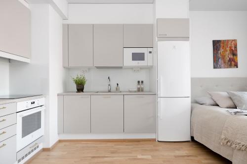 a white kitchen with a bed and a sink at 2BR design home 400 m from train station Tikkurila in Vantaa