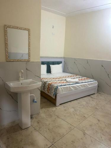Moonlight hotel greater Noida في نويدا الكبرى: غرفة نوم مع سرير مع حوض ومرآة