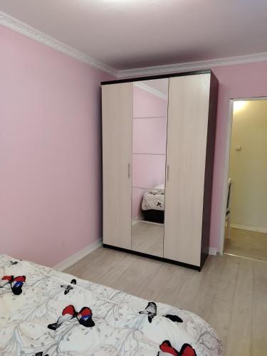 1 dormitorio con espejo y 1 cama en Двухкомнатная квартира в центре города, en Almaty