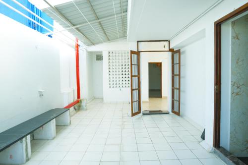 an empty hallway of a building with a door and benches at SAARA INN in Puducherry