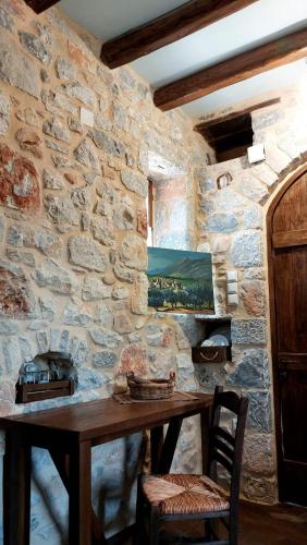 pared de piedra con mesa de madera en una habitación en Studio Tsiliviani, en Loukádhika