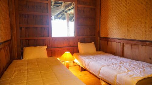 1 dormitorio con 2 camas y lámpara. en Baleluhur Villa Ciwidey, en Panundaan