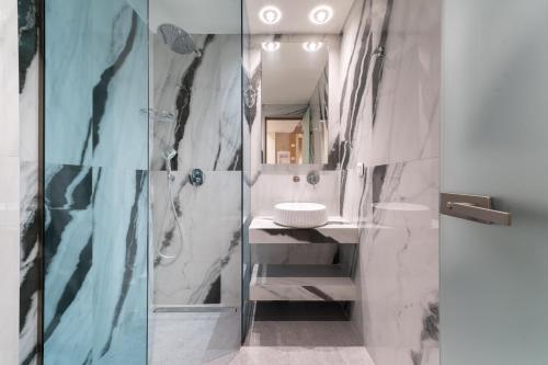 a bathroom with a glass shower and a sink at Reverie in Limenaria