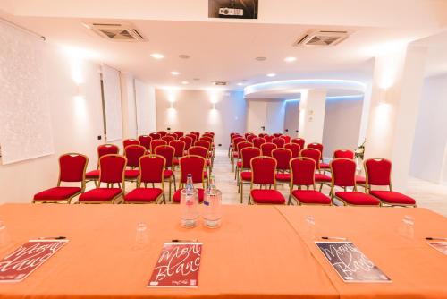 a conference room with a long table and red chairs at Hotel Villa Ida in Ceprano