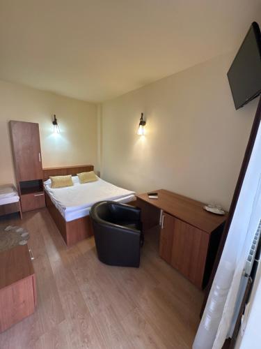 a room with a bed and a desk and a chair at Pensiunea Drobeta in Drobeta-Turnu Severin