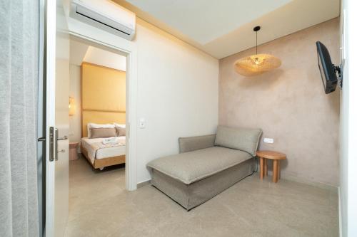 a living room with a chair and a bed at Reverie in Limenaria