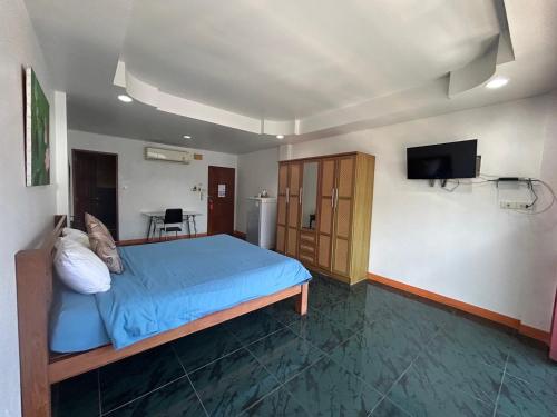 a bedroom with a blue bed and a flat screen tv at Coffeeandbeer in Pattaya South