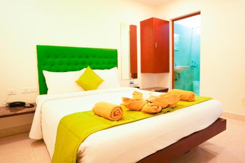 a bedroom with a large bed with towels on it at SAARA INN in Puducherry
