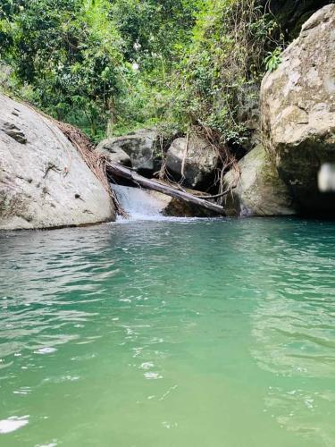 a boat sitting in the water next to some rocks at Dinimuthu Rest Inn in Wellawaya