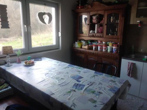 Landhaus في Bosanska Dubica: مطبخ مع طاولة عليها قطعة قماش