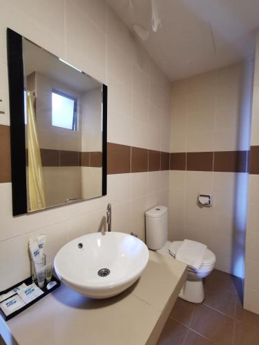a bathroom with a white sink and a toilet at Bayou Lagoon Park Resort in Melaka