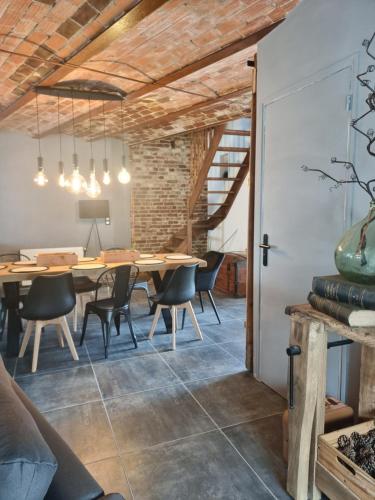 ein industrielles Esszimmer mit einem Holztisch und Stühlen in der Unterkunft Échappée belle en baie de Somme in Saint-Quentin-Lamotte-Croix-au-Bailly