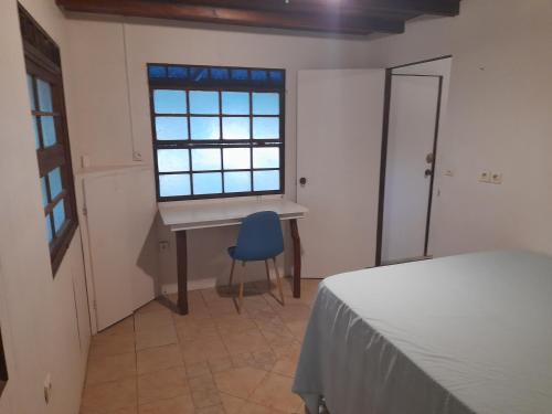 - une chambre avec un bureau et une chaise bleue dans l'établissement HINAMOE LODGE, à Avatoru