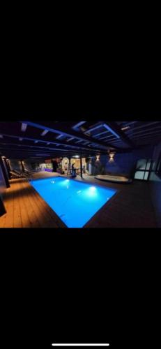 a large swimming pool at night with blue lighting at הוילה הסודית שלי in Kefar H̱ananya
