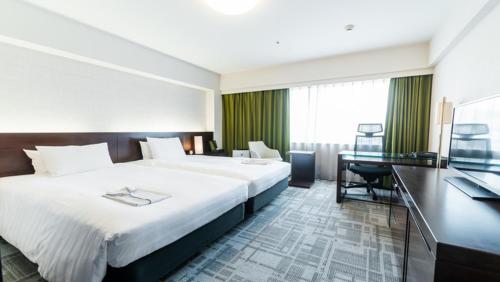 Cette chambre comprend un grand lit et un bureau. dans l'établissement Richmond Hotel Kagoshima Tenmonkan, à Kagoshima
