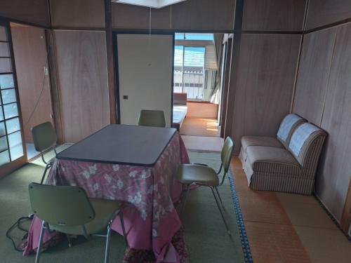 a room with a table and chairs and a couch at 名高儀の宿 in Iwaki