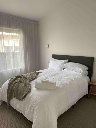 ein Schlafzimmer mit einem großen Bett mit zwei Handtüchern darauf in der Unterkunft The Minnie on Prince- Central & stylish in Orange