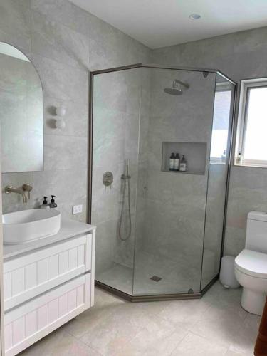 ein Bad mit einer Dusche, einem Waschbecken und einem WC in der Unterkunft The Minnie on Prince- Central & stylish in Orange