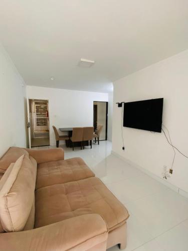 een woonkamer met een bank en een flatscreen-tv bij Apartamento Amplo Luzia Próx Shopping Jardins in Aracaju