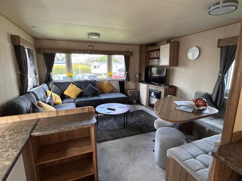 uma sala de estar com um sofá e uma mesa em Sussex by the sea holiday home em Hastings