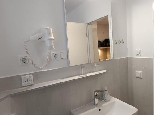 a white bathroom with a sink and a mirror at Kastanienhof Lübben in Lübben
