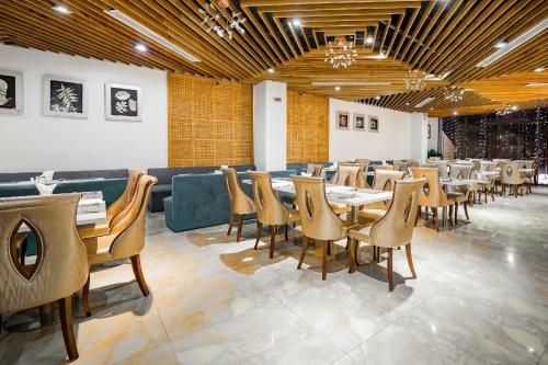 a restaurant with tables and chairs in a room at TND Hotel in Nha Trang