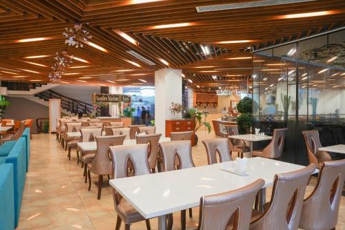a restaurant with tables and chairs in a room at TND Hotel in Nha Trang