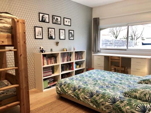 - une chambre avec un lit et une étagère avec des livres dans l'établissement Chambre dans belle maison à Lattes, à Lattes