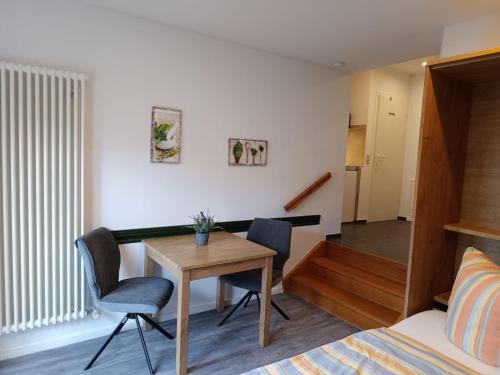 リュッベンにあるKastanienhof Lübbenのテーブル、椅子、ベッドが備わる客室です。