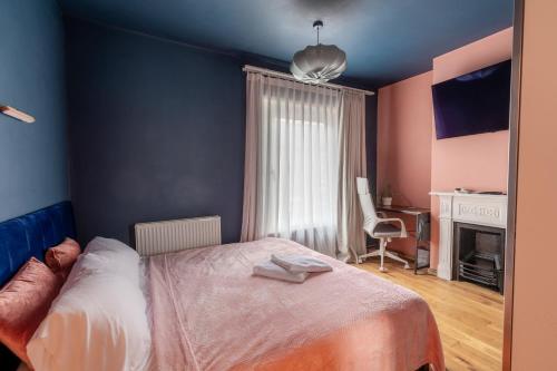 1 dormitorio con cama, escritorio y silla en Milton Keynes Cosy Guest House en Milton Keynes